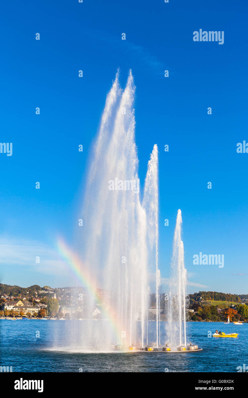 Beautiful view of the fountain at  Mythenquai with rainbow in the Zurich lake at sunset, Switzerland Stock Photo