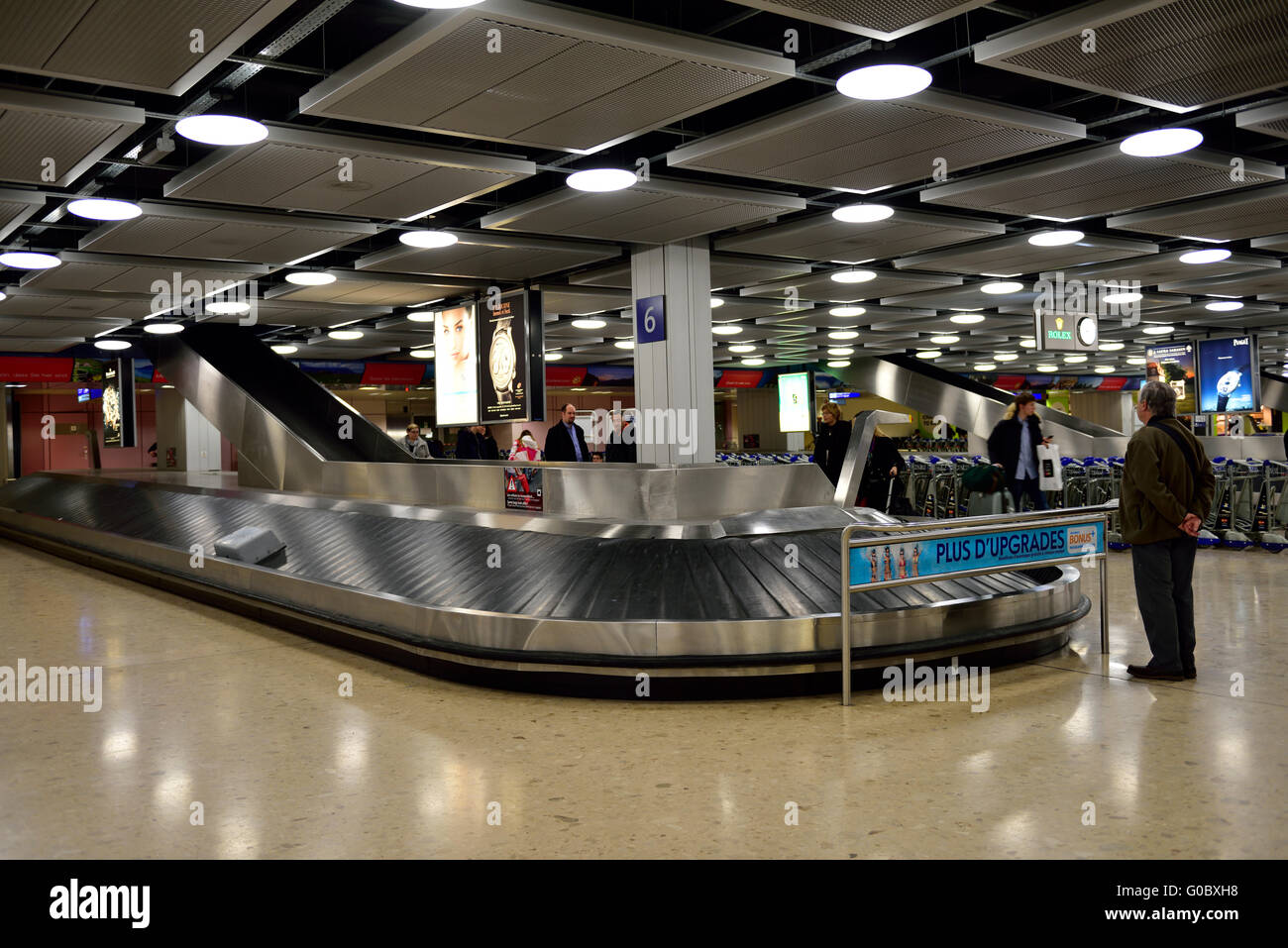 Airport baggage reclaim carousel man waiting for his bag, Geneva airport Stock Photo