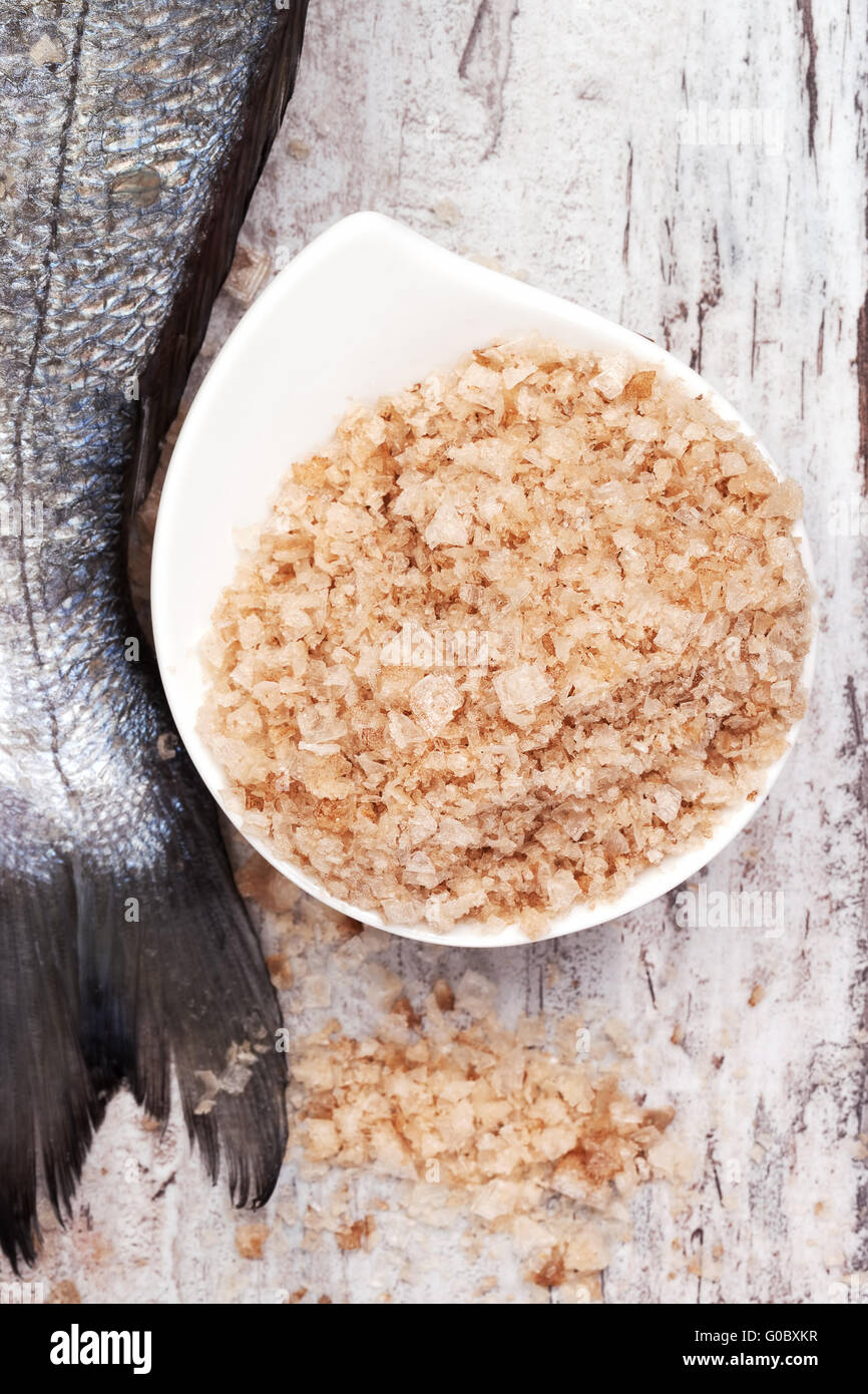 Seasalt in bowl and raw fish tail. Seafood background Stock Photo Alamy