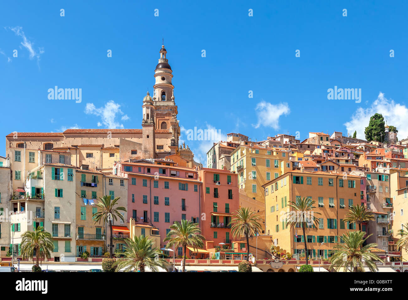Belfry among colorful houses under blue sky in old town of Menton, France. Stock Photo