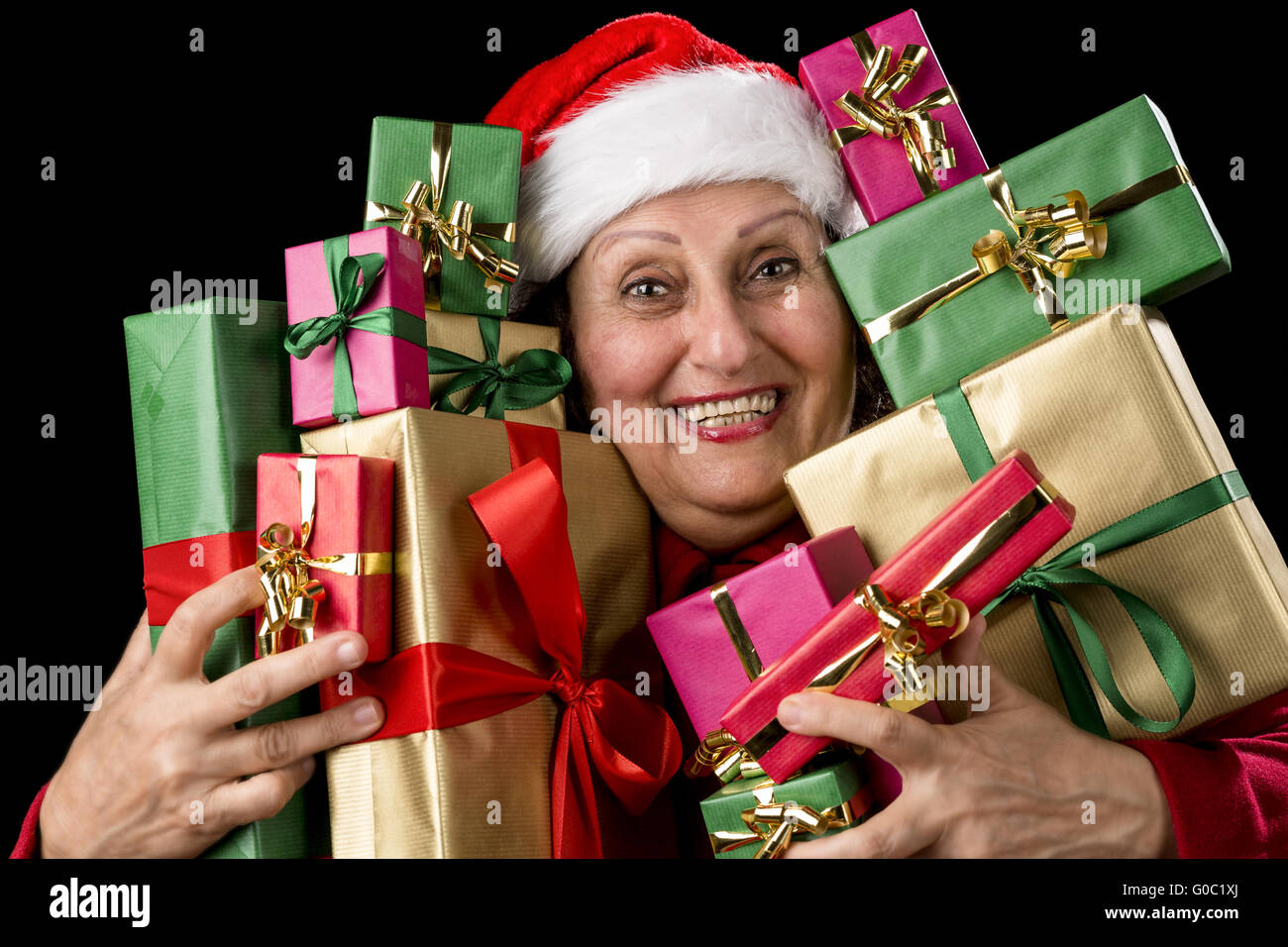 Delighted Old Lady Hugging a Dozen Wrapped Gifts Stock Photo