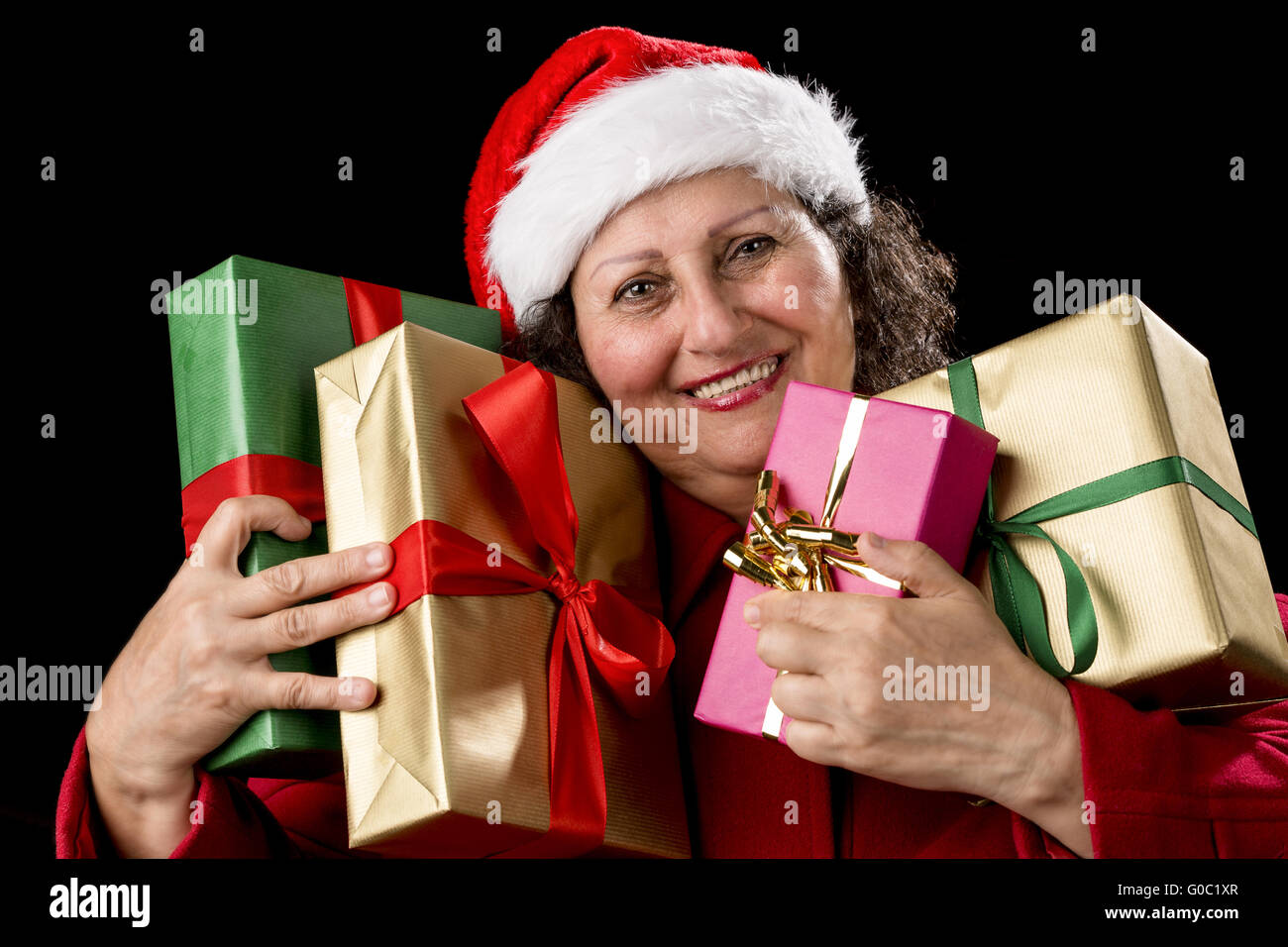 Smiling Aged Woman Embracing Four Wrapped Gifts Stock Photo
