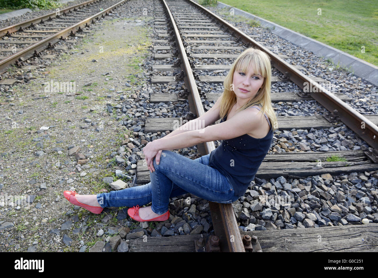 woman sitting on rail track Stock Photo