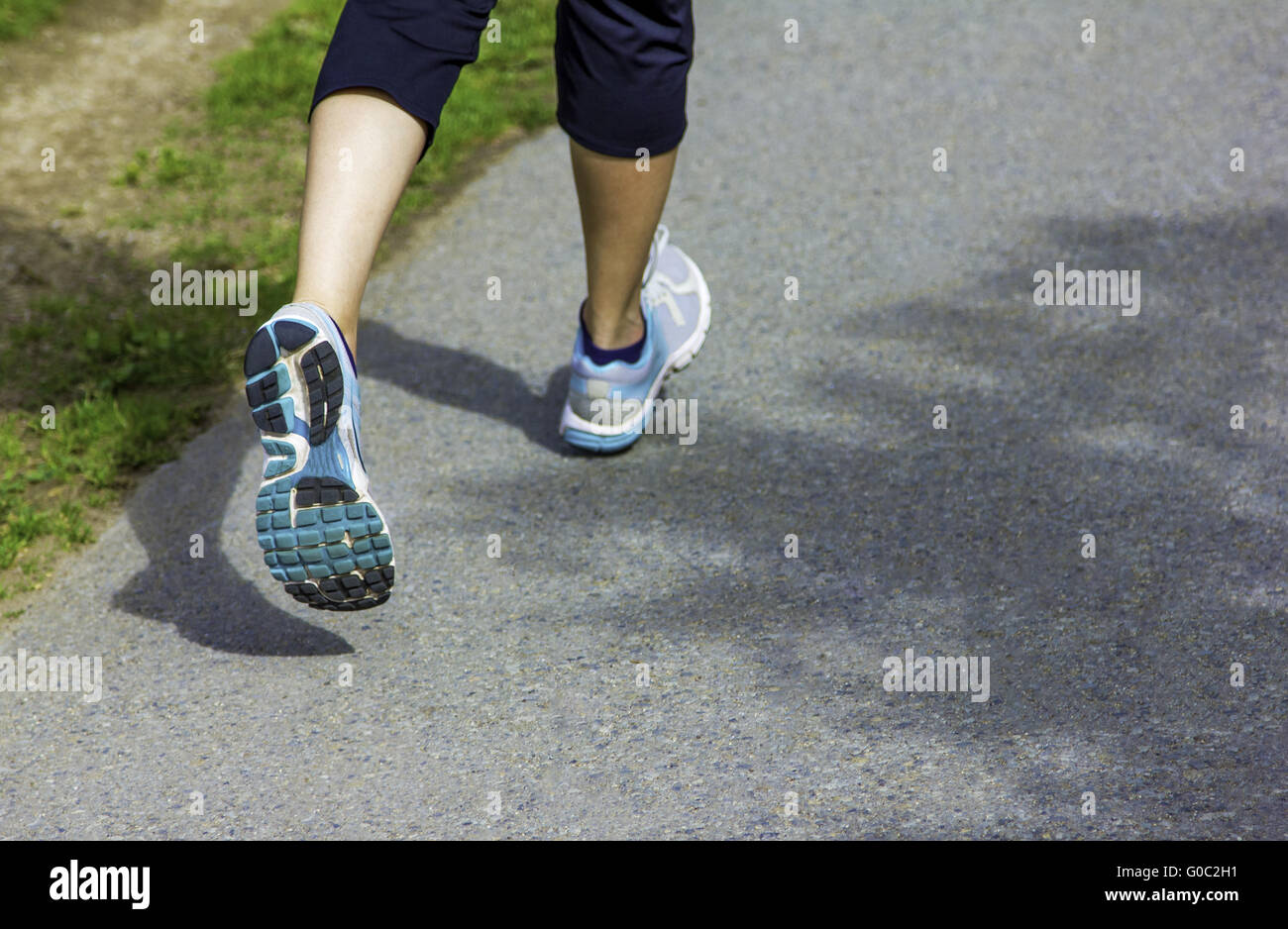 Runner - running shoes closeup on runners shoes feet running on road ...