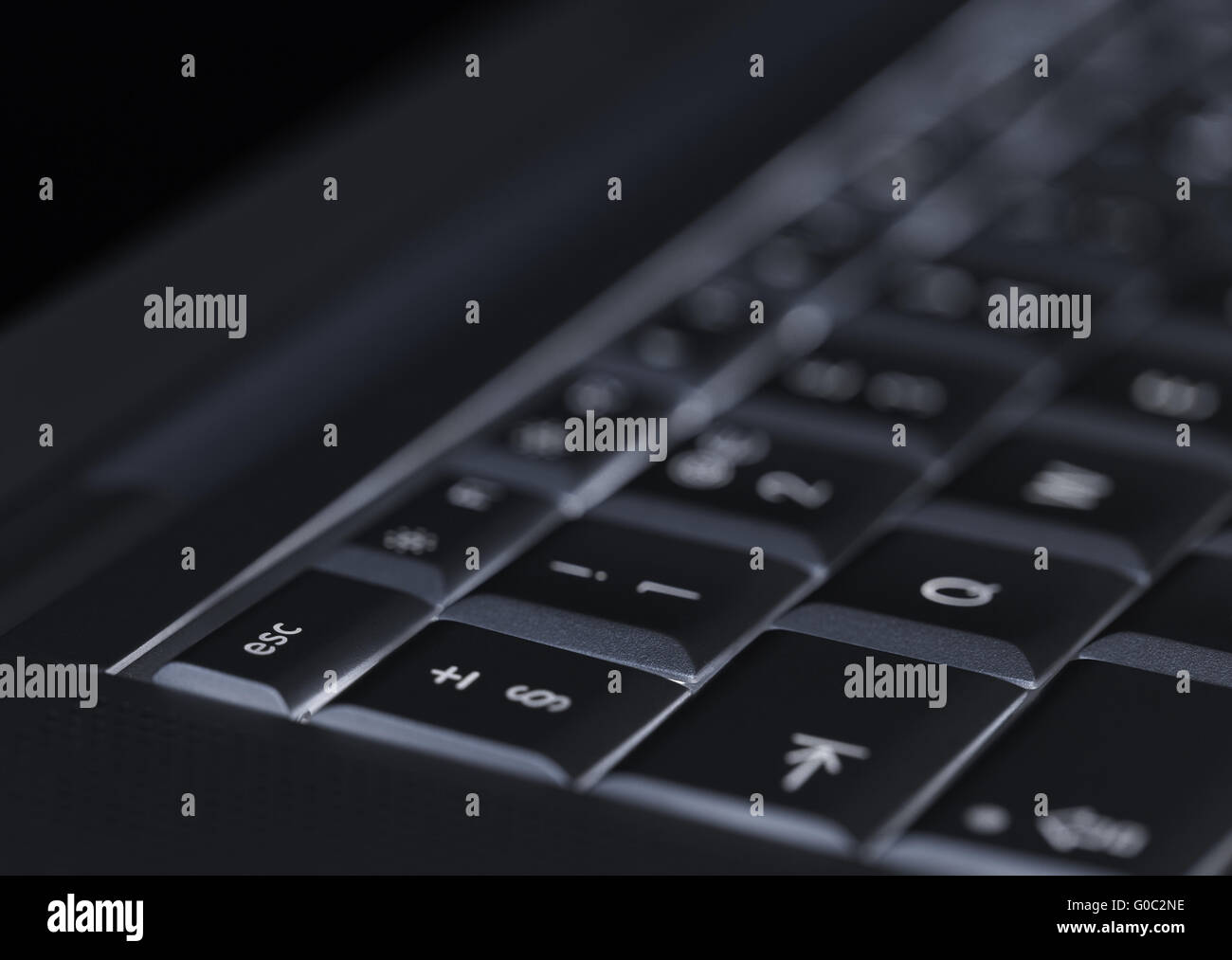 Closeup of backlit computer laptop keyboard selective focus on escape key ideal for technology night hacker standout Stock Photo