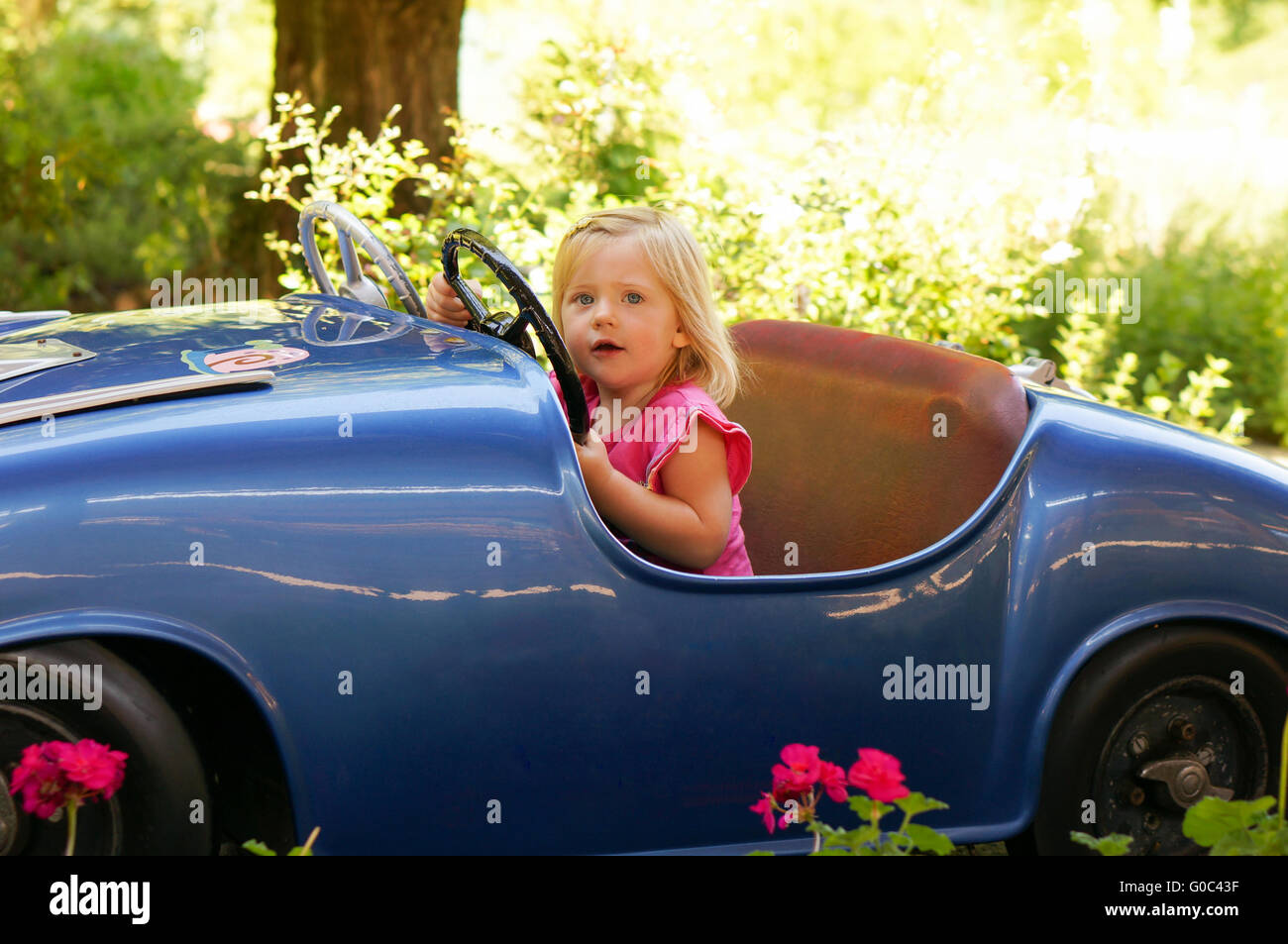 little girl in a fun fair drive car Stock Photo