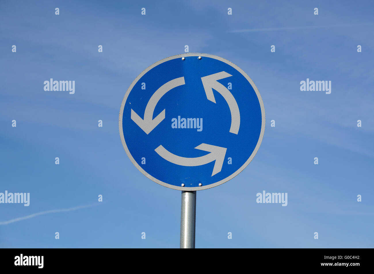 roundabout traffic sign in blue sky Stock Photo