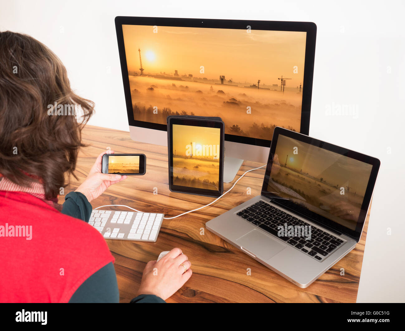 Woman with networked computer and mobile devices Stock Photo
