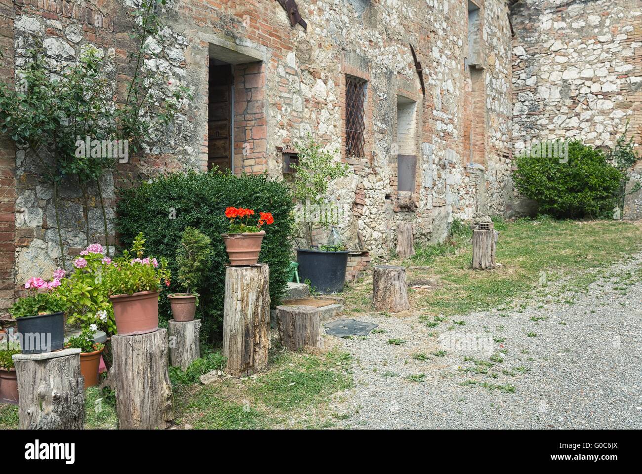 Stony antique wall with flowers in italian village Stock Photo - Alamy
