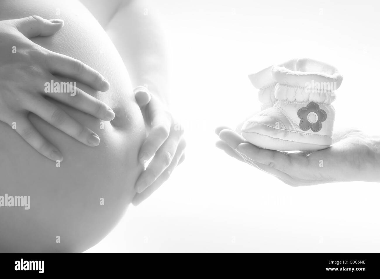 Close-up of a Pregnant Woman and her Husband holding children's shoes Stock Photo