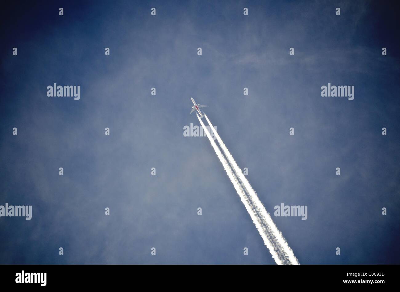 airliner with condensation trail at a blue sky Stock Photo