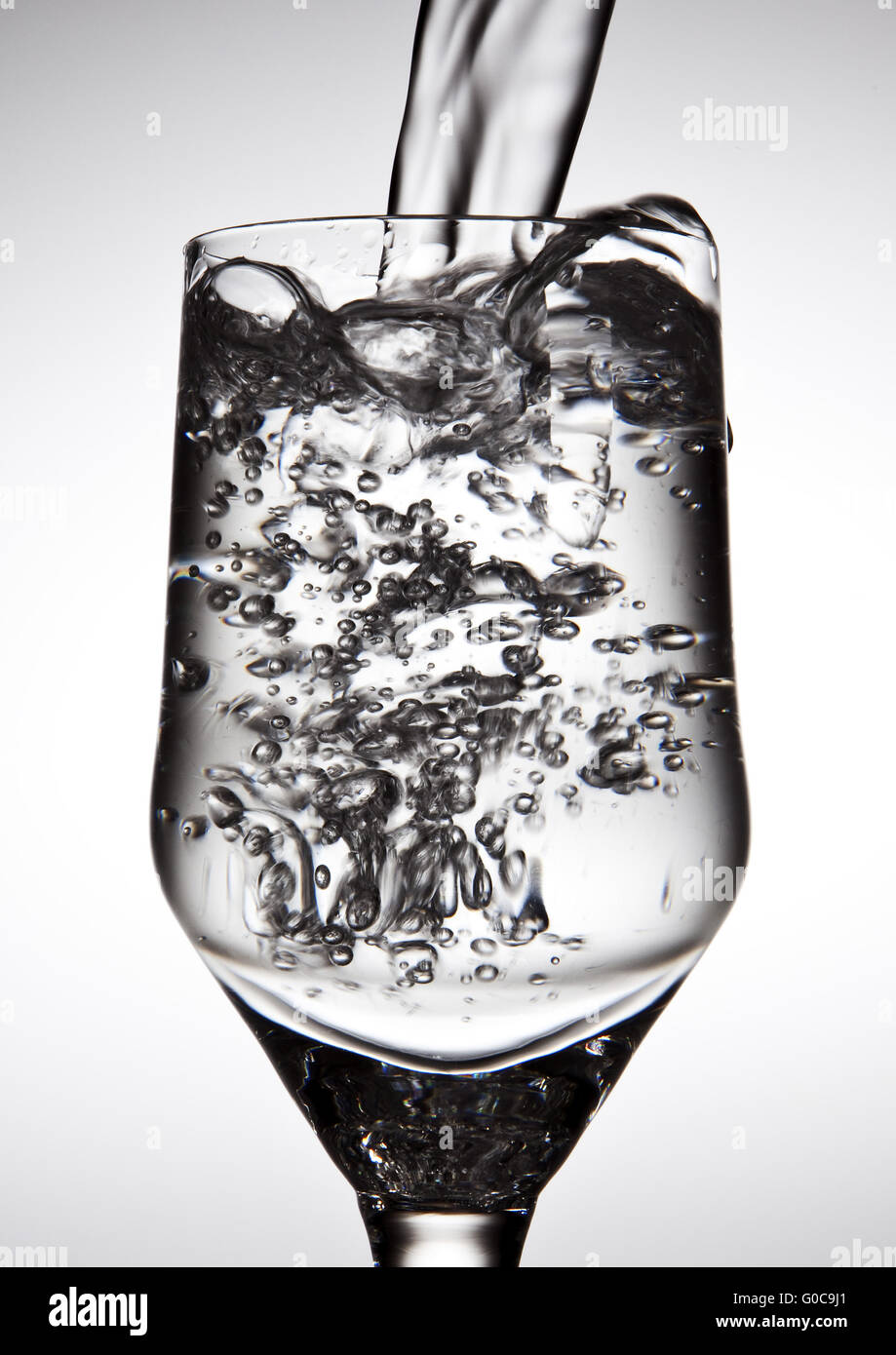 Water is being poured into a glass Stock Photo