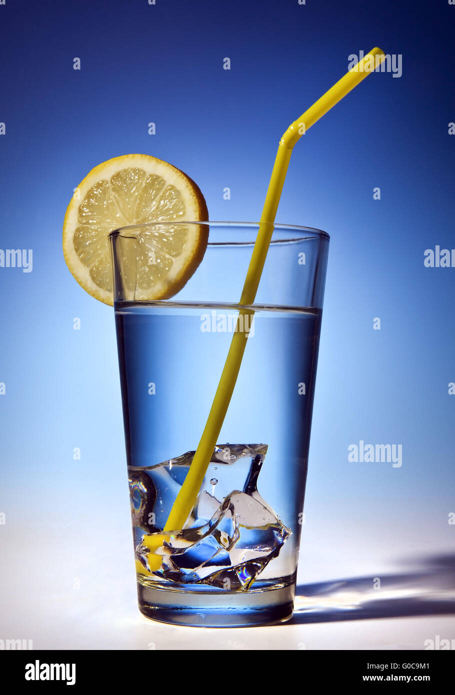 Water glass with ice cubes and lemon slice Stock Photo