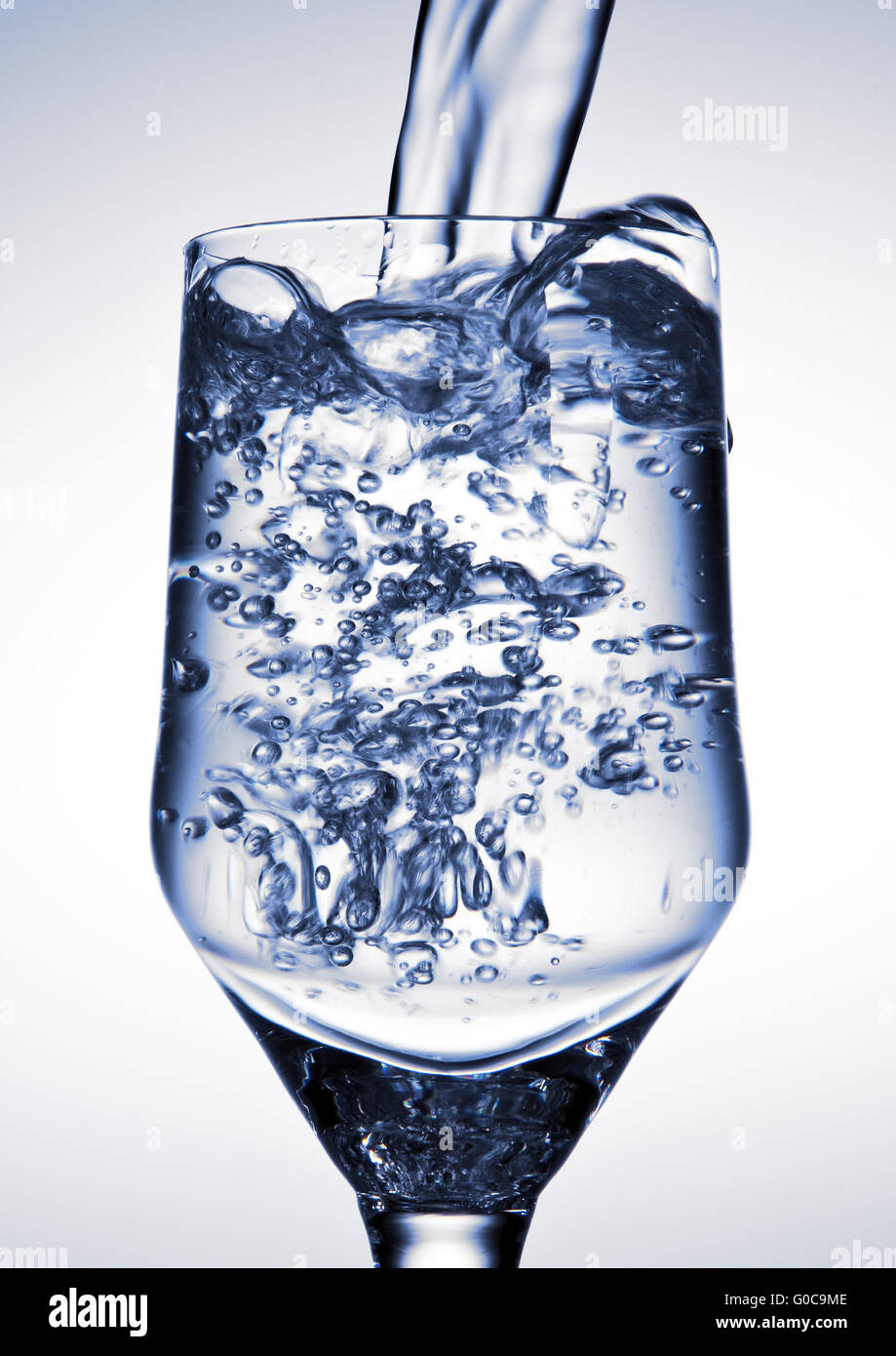 Water is being poured into a glass Stock Photo