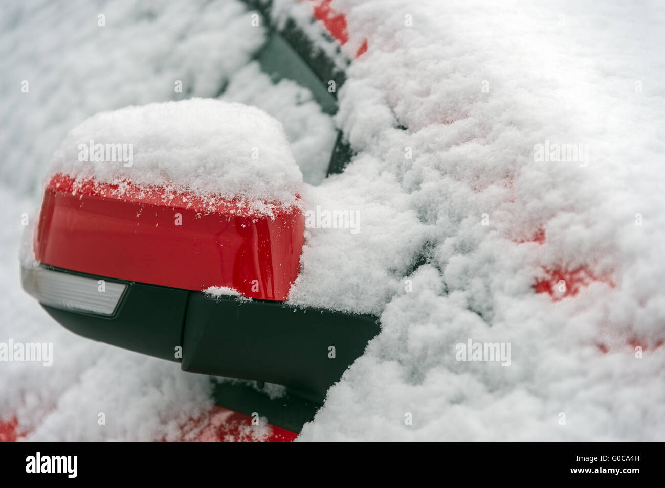 snowy, red rear view mirror of a car Stock Photo