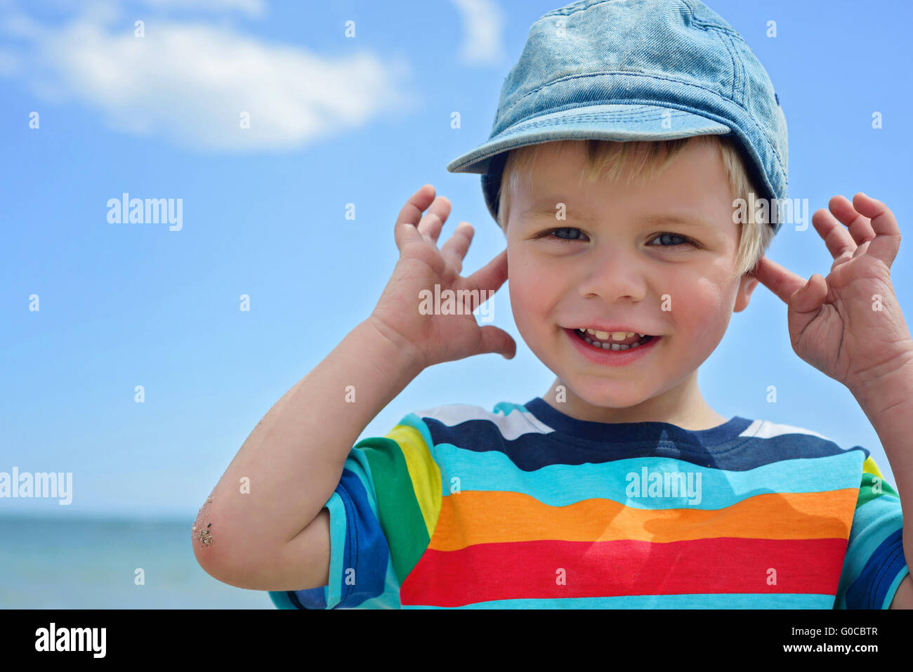 Small boy holds his hands over ears not to hear Stock Photo