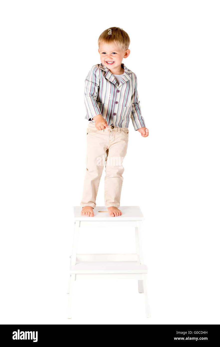 Boy shot in the studio on a white background standing on stool Stock Photo