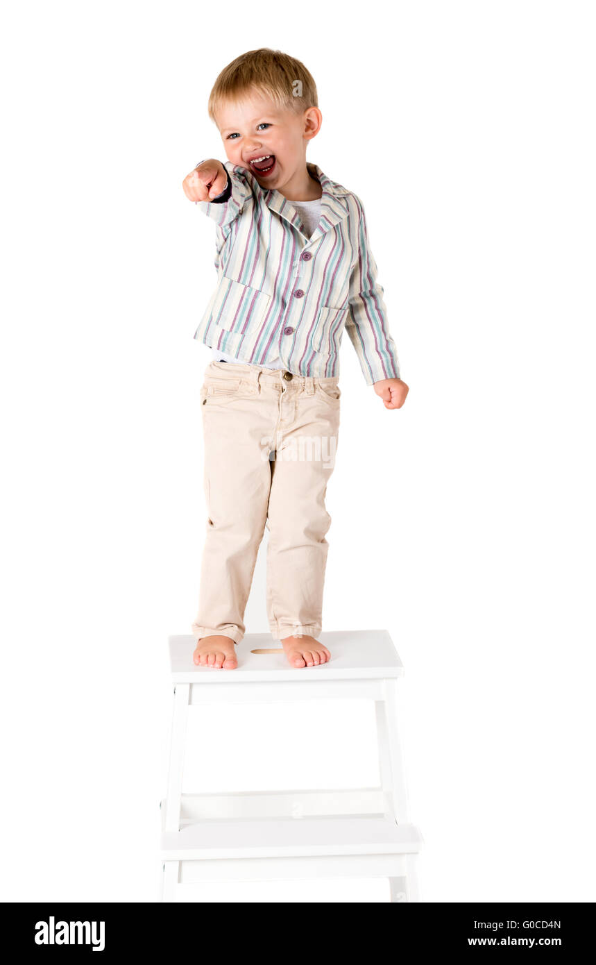 Boy shot in the studio on a white background standing pointing Stock Photo