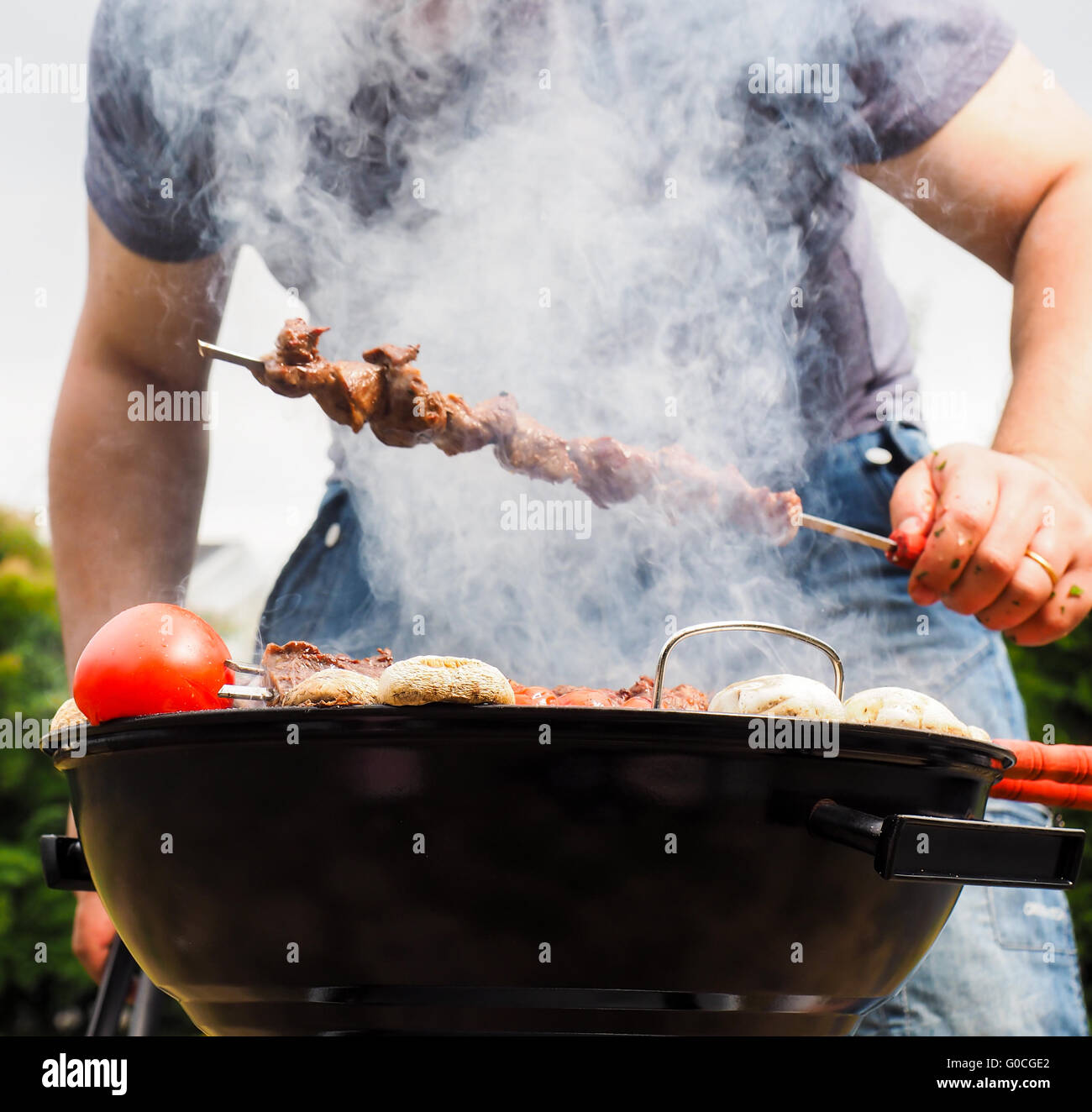 Chef in smoke grilling skewers over barbecue Stock Photo Alamy