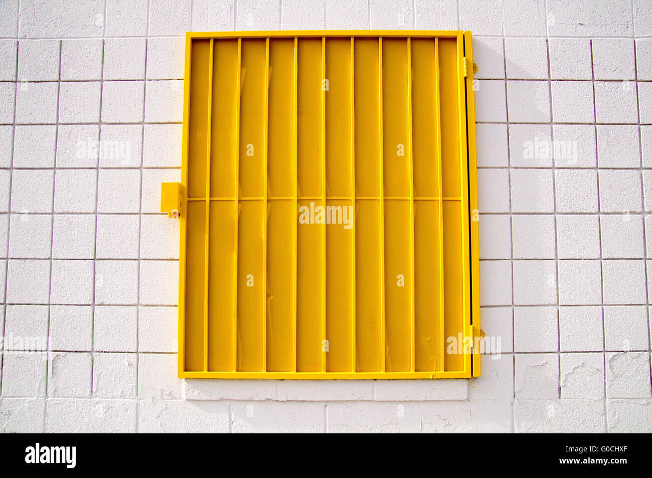 Yellow mesh shutter on white wall Stock Photo