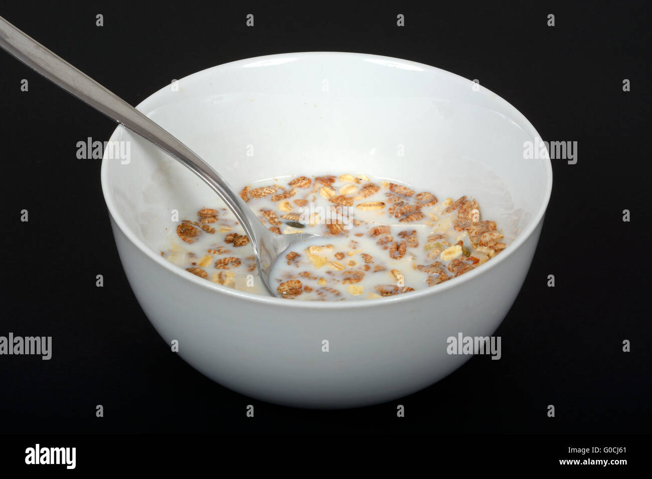 Muesli with a mix of healthy fruit, nuts and seeds and milk in a dish