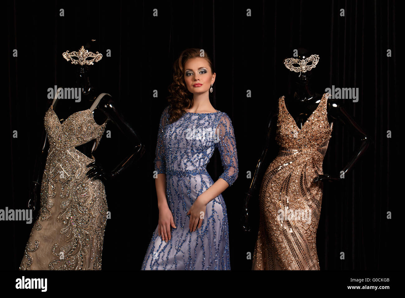 fashionable woman in blue dress with rhinestones and mannequins Stock Photo