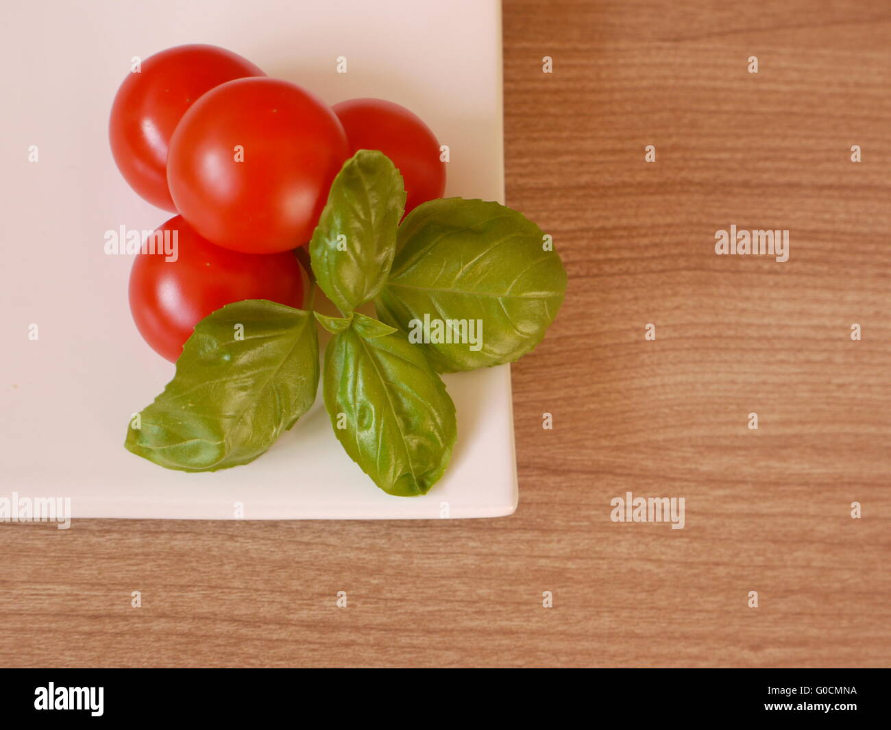 Tomatoes with basil Stock Photo - Alamy