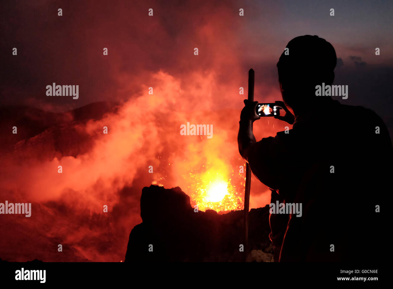 A man gazing at a volcanic eruption from the crater of the Pacaya an ...