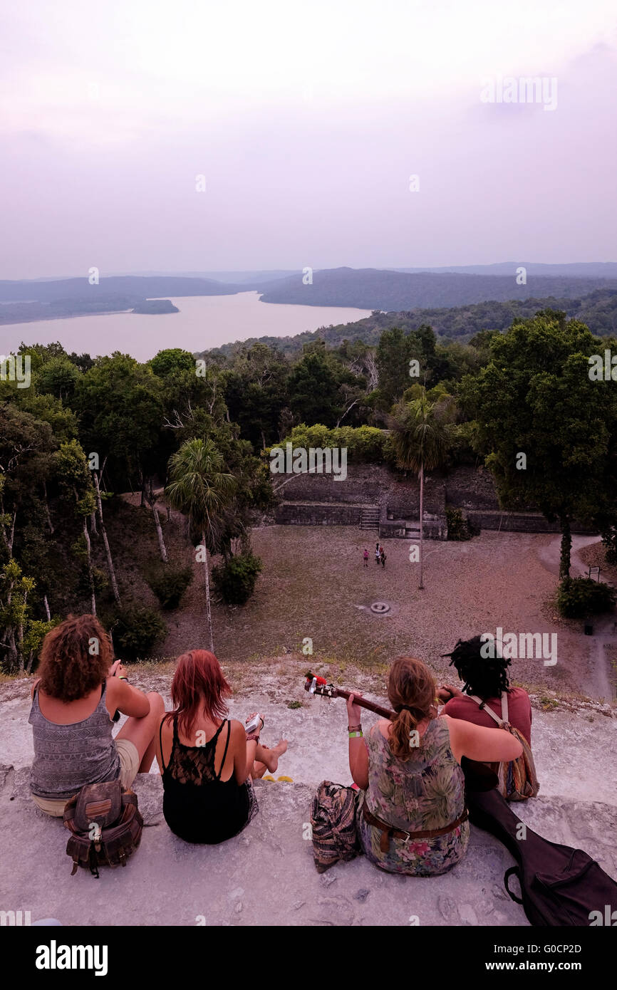 Tourists gazing at Lake Peten Itza from an ancient Mayan ruin in Yaxha ...