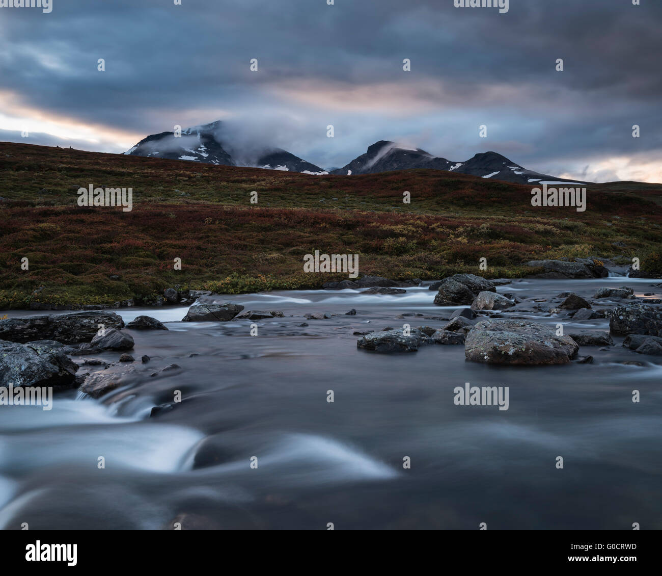 Flowing river outside of Syter hut with mountains of Norra Stofjället in background, Kungsleden trail, Lapland, Sweden Stock Photo
