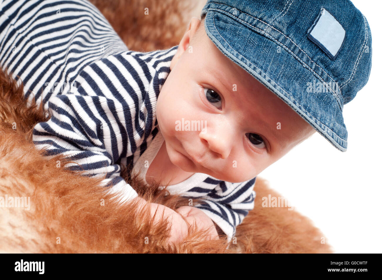 Portrait of adorable baby in cap lying on fur Stock Photo