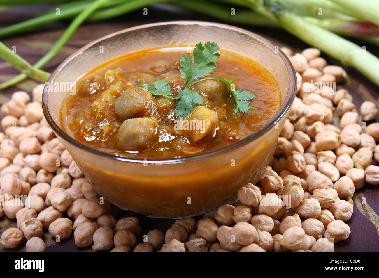 indian spicy chana masala with raw chickpeas and green onion Stock