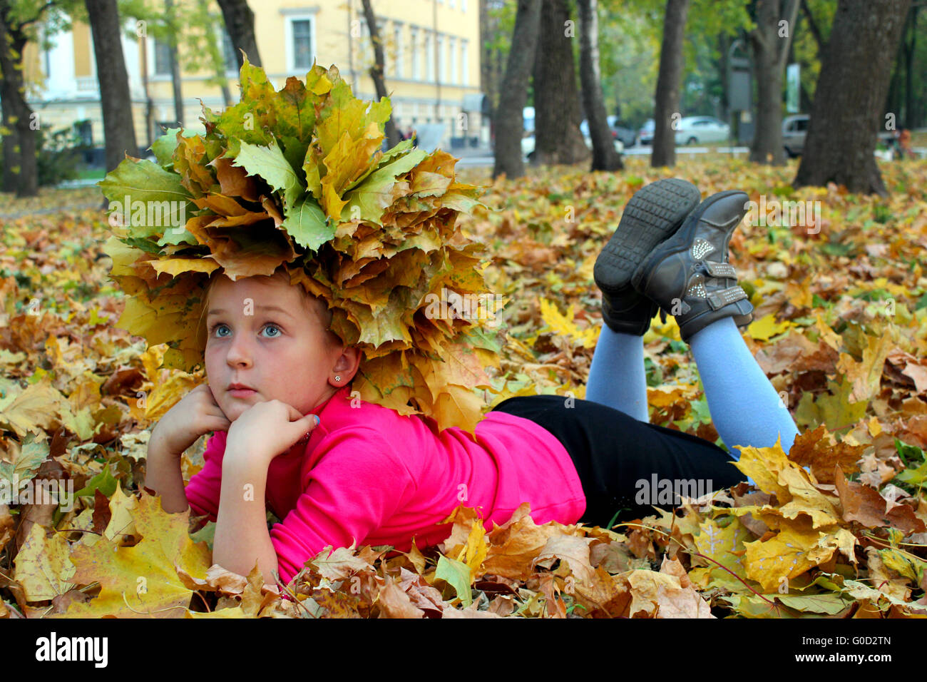 little girl lying on the yellow leaves in the park Stock Photo - Alamy