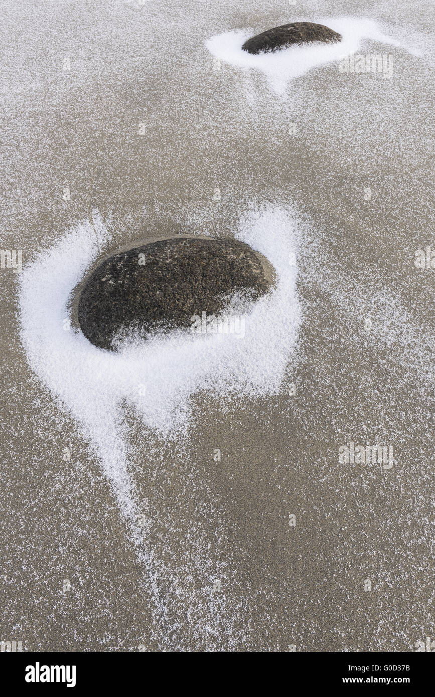 snowy stones on a sandy beach, Lofoten, Norway Stock Photo