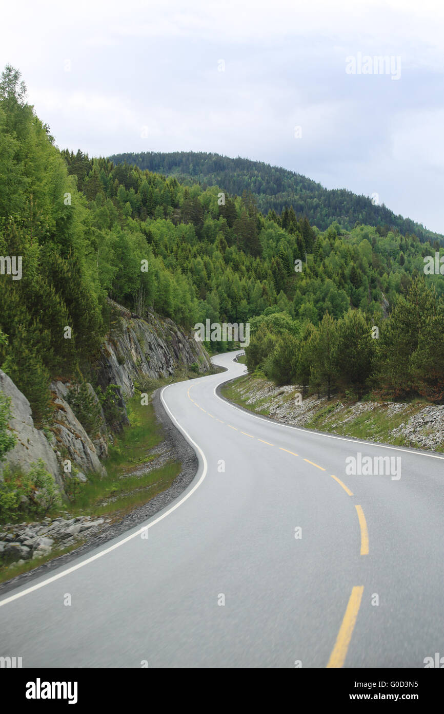 View on mountain road, rocks and forest at nasty summer day Stock Photo ...