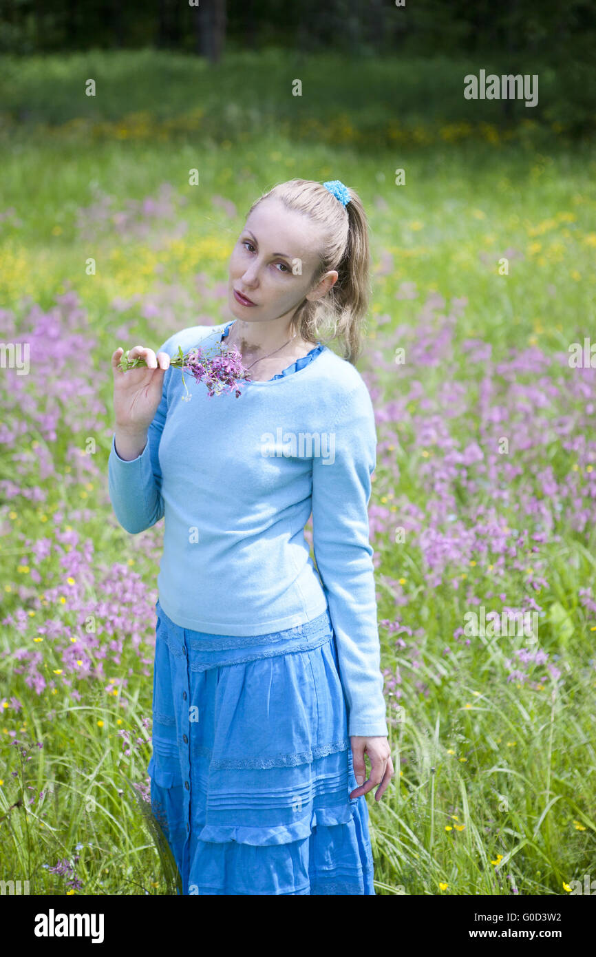 young woman in a blue dress in the field Stock Photo - Alamy