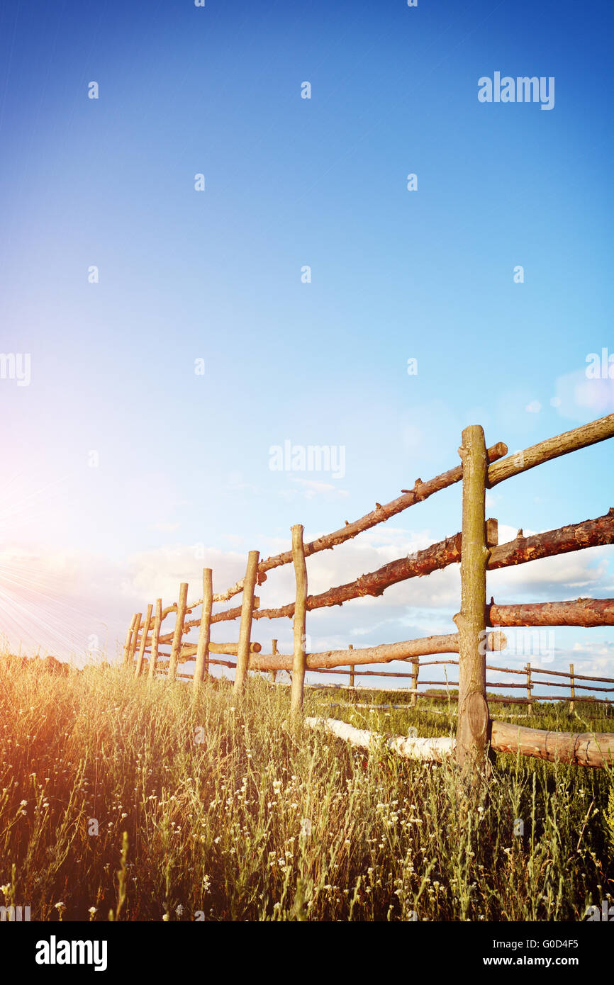 Fence in the green field under blue cloud sky Stock Photo - Alamy