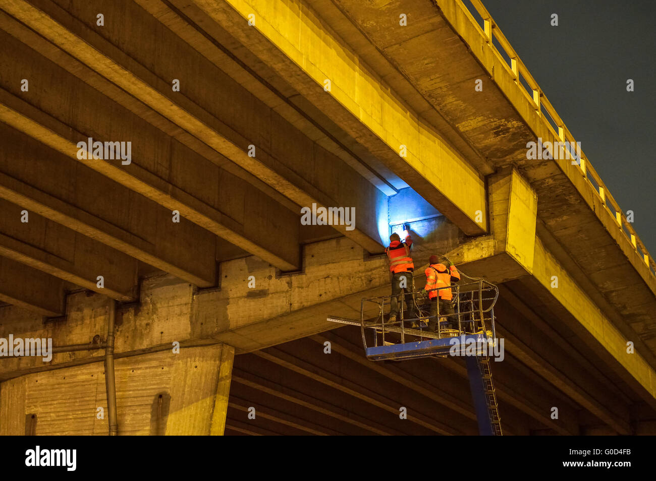 Workers inspect a bridge highway at night Stock Photo