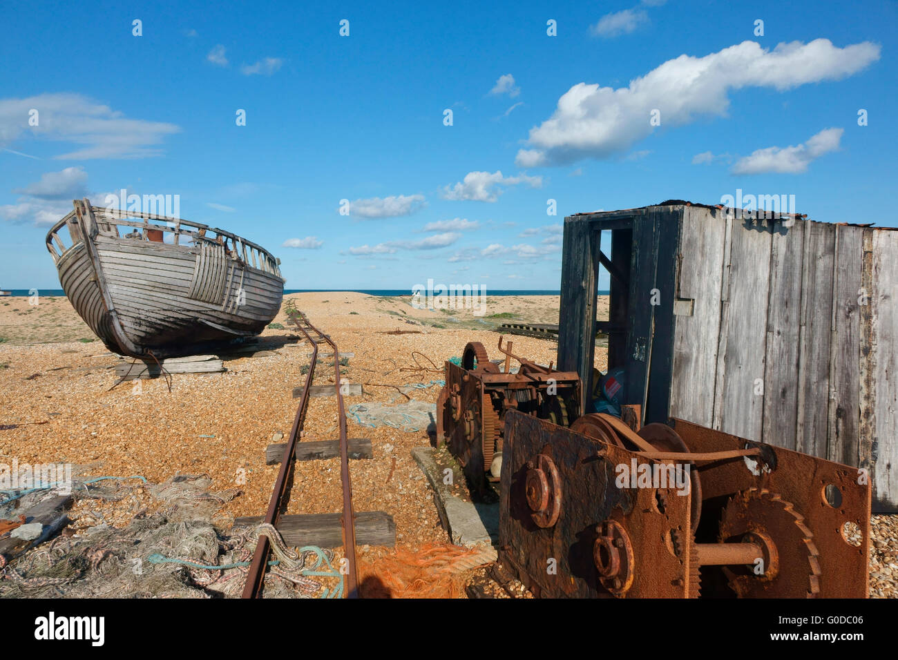 Abandoned fishing boat and winch on Dungeness shingle beach Kent England UK. The desolate landscape a favourite with photographers Stock Photo