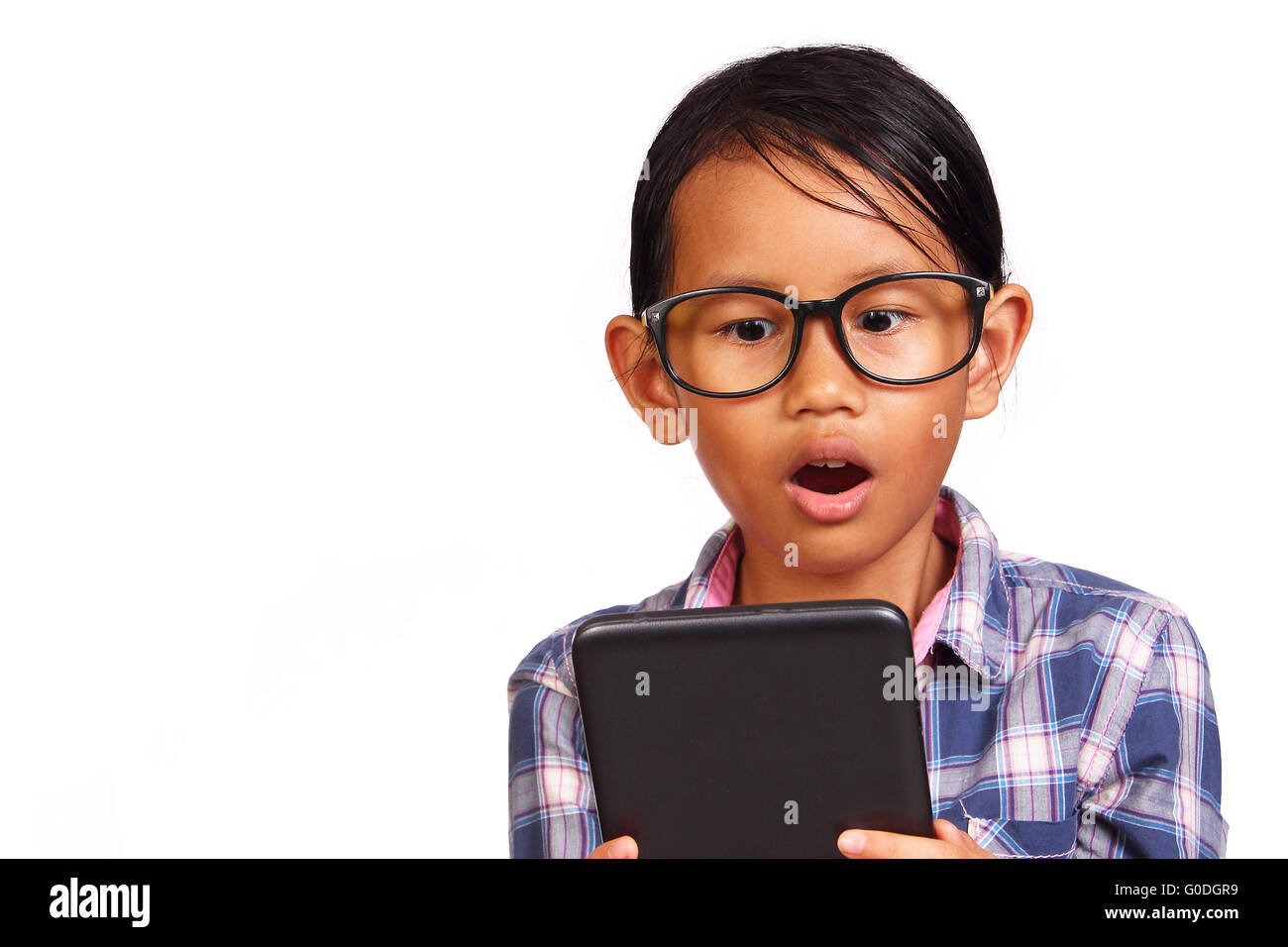 Little girl with glasses shocked while looking her tablet isolated on white Stock Photo