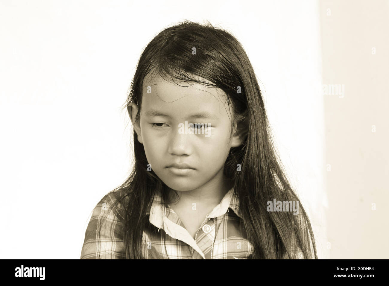 Sad and crying little girl looking down in monochrome Stock Photo