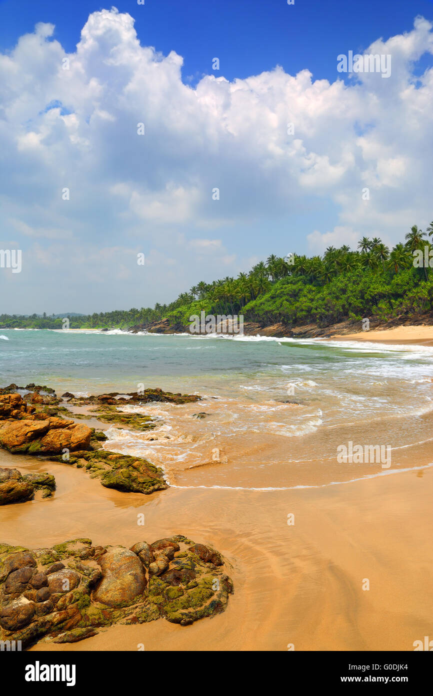 sea waves on tropical beach with stones and rocks Stock Photo