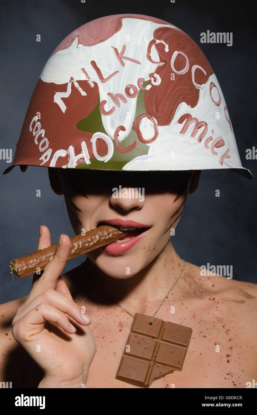 Beautiful woman with chocolate cigar in hand and helmet Stock Photo