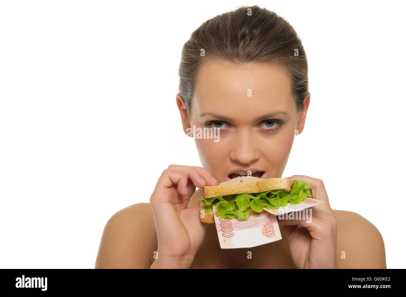 Woman biting a sandwich out of money and lettuce Stock Photo