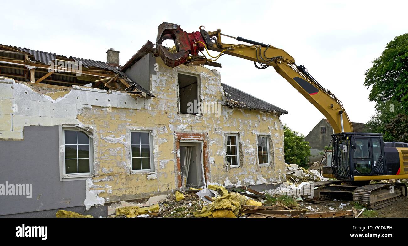 demolition of a residential house by a digger Stock Photo