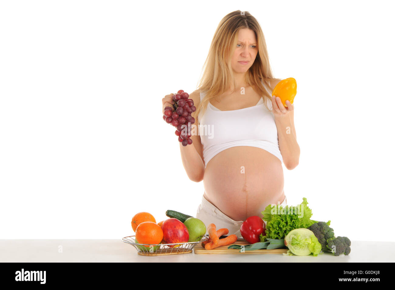 Unhappy pregnant woman with fruits and vegetables Stock Photo