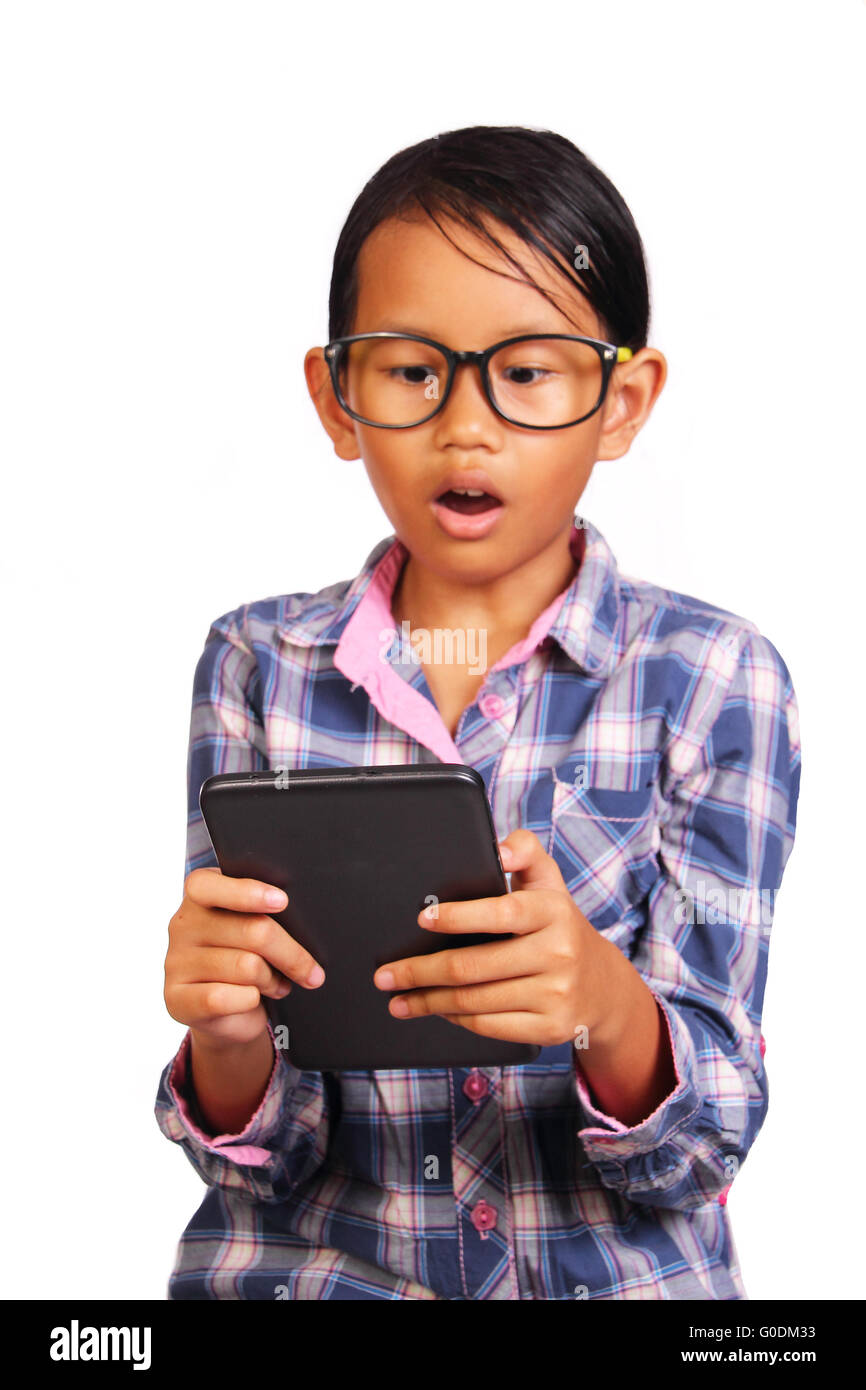 Little girl with glasses shocked while looking her tablet isolated on white Stock Photo