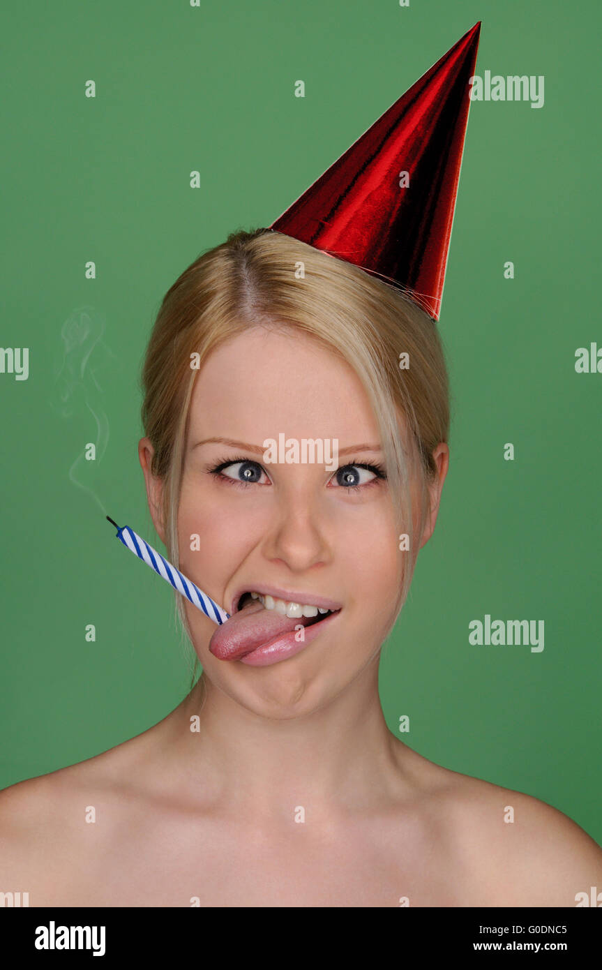 woman with candle extinguished and festive cap Stock Photo