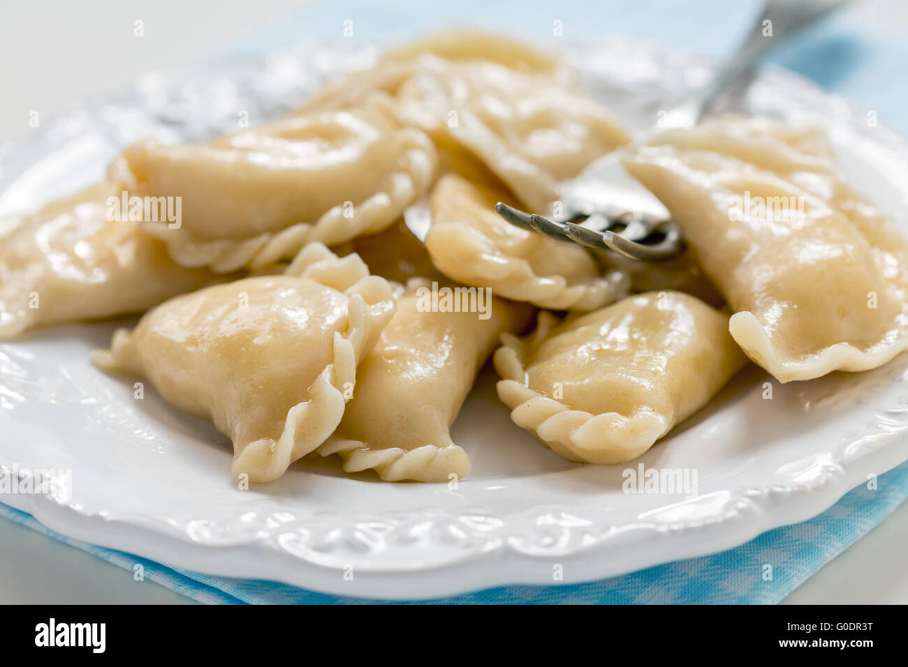 Dumplings with cottage cheese and fork on the plate. Stock Photo