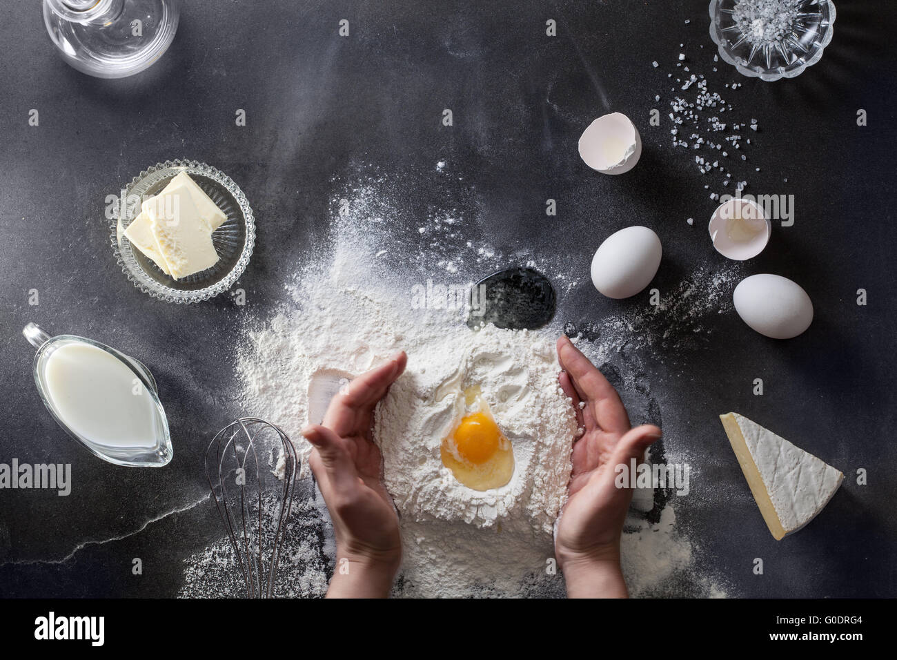 Woman's hands knead dough on table with flour Stock Photo - Alamy